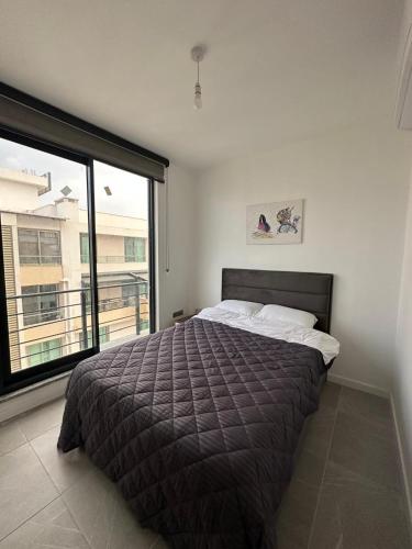 a bedroom with a bed and a large window at Moonlight Home in Nicosia