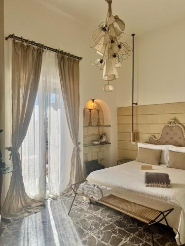 a bedroom with a bed and a large window at HABITARE Lecce & Salento in Lecce
