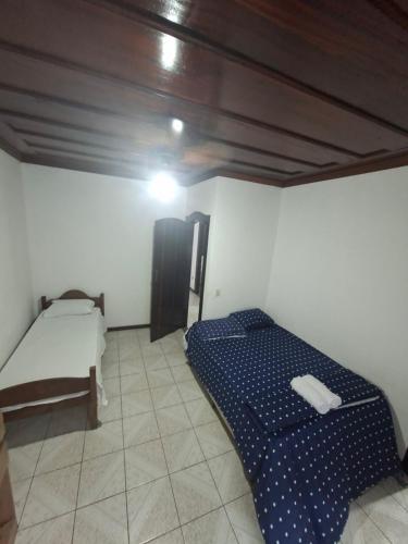 Casa de Hospedagem Flores Paraty 2 في باراتي: غرفة صغيرة بها سرير وطاولة