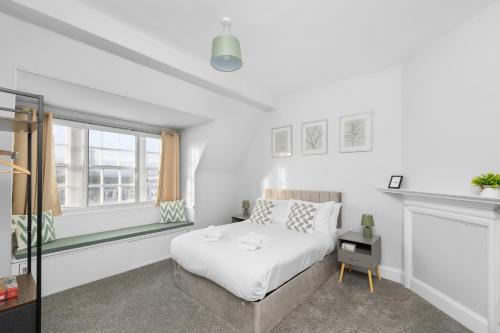 ein weißes Schlafzimmer mit einem Bett und einem Fenster in der Unterkunft Lochside Apt, D in Region Angus