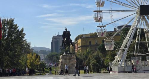una statua di un uomo a cavallo e una ruota panoramica di STAY-FIVE Cozy Modern Studios in Tirana Center - Brand New a Tirana