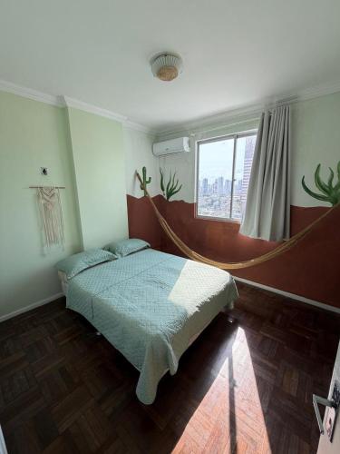 a bedroom with a bed in a room with a window at Spacious & Artistic Apartment in Belém in Belém