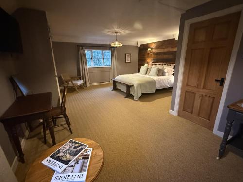 a large bedroom with a bed and a table with a table sidx sidx at The Lord Raglan in Staplehurst