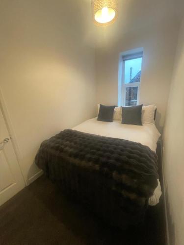 a bedroom with a large bed with a window at Fairy Cove Cottage in Paignton