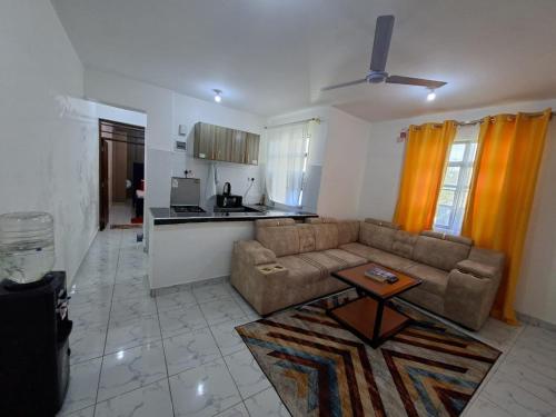 a living room with a couch and a kitchen at Home by Mercy Apiyo in Mombasa
