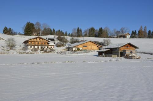 a group of wooden buildings in the snow at Langegger Alm - Sennerstube in Helmenstein