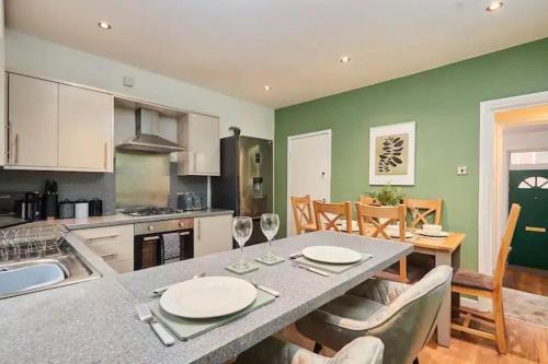 a kitchen with a table with two wine glasses at The Bluebird Rooms II in Headingley