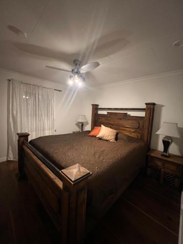 Schlafzimmer mit einem Holzbett und einem Deckenventilator in der Unterkunft Gävle Guest House in Gävle