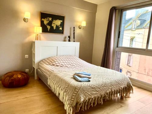 a bedroom with a bed and a large window at Appartement moderne baigné de lumière en centre-ville in Douarnenez
