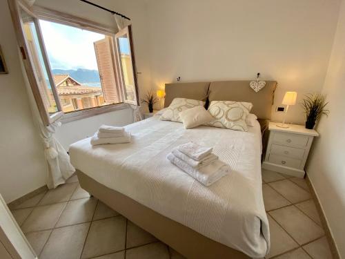 ISA - Luxury apartment Elicriso sea view with common swimming pool just 100 mt from the beach في غولفو أرانتْشي: غرفة نوم بها سرير كبير مع مناشف عليه