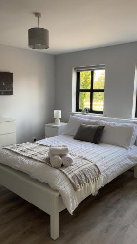 a white bedroom with a large bed with two towels on it at Bragan Mountain View in Monaghan
