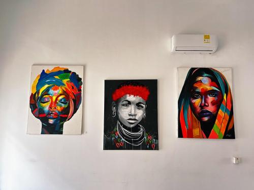 three paintings of a woman on a wall at Art House Getsemaní in Cartagena de Indias