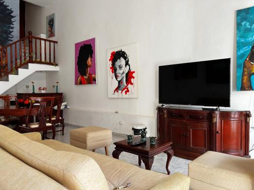 a living room with a couch and a flat screen tv at Art House Getsemaní in Cartagena de Indias