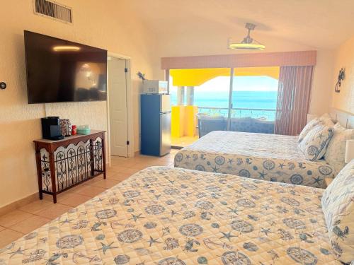 una camera con 2 letti e un frigorifero di Princesa 3BR 2BA OV Penthouse- 502D a Campo del Medio