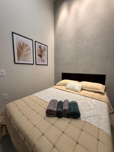 a bedroom with a bed with two towels on it at Loft Prime Andradina in Andradina