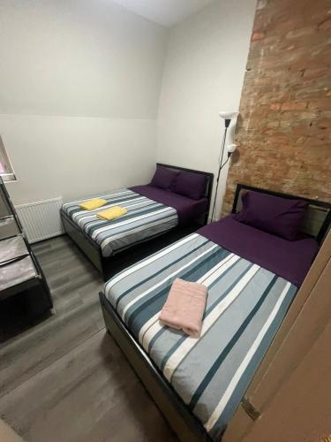 two beds in a small room with purple beds at Central Downtown New Year Stay- Self Checkin & Free Wifi in Toronto