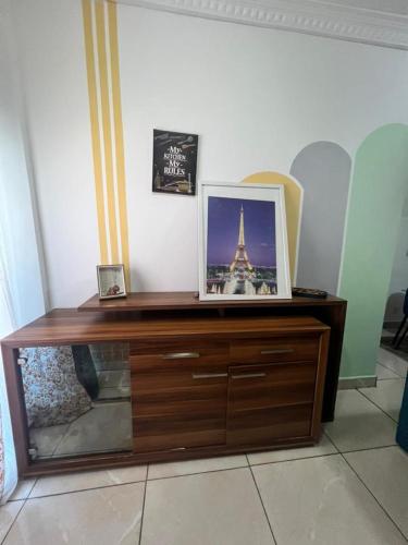 a wooden dresser with a picture of the eiffel tower at Wharf 303 in Pointe-Noire