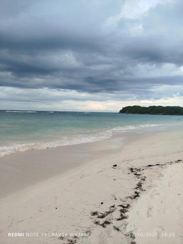 einen Strand mit Fußabdrücken im Sand und im Ozean in der Unterkunft Parador tropical in Las Galeras