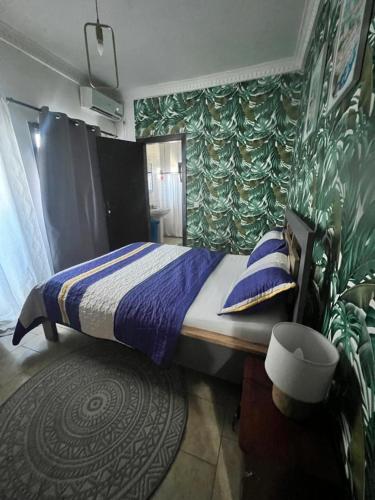 a bedroom with a large bed with blue pillows at Wharf 303 in Pointe-Noire