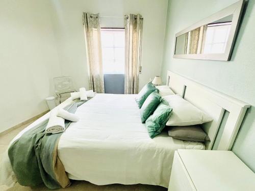 een groot wit bed in een kamer met een raam bij Casa do Omega do Foz in Foz do Arelho