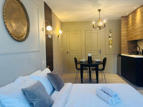 ein Schlafzimmer mit Bett und Tisch und eine Küche in der Unterkunft Sweet Escape - Studio privé proche du lac du Der in Frignicourt