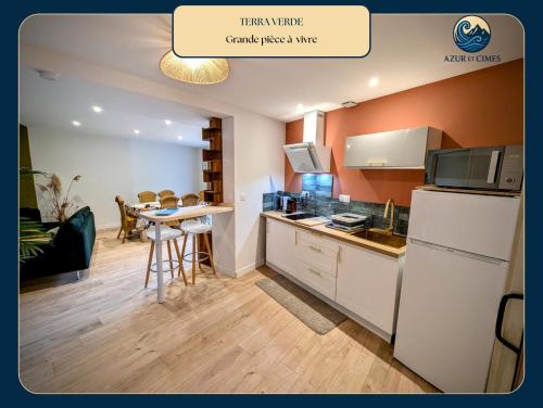 een keuken met een witte koelkast en een tafel bij Terra Verde Appartement nature tout équipé près de Gap in Gap