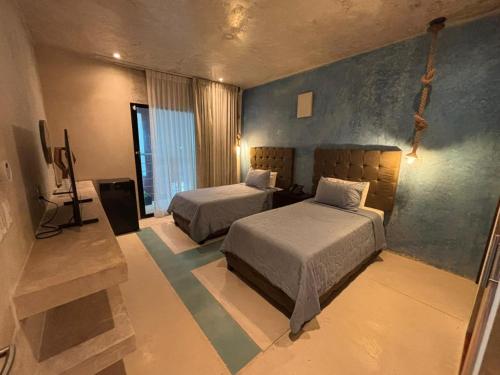 ein Schlafzimmer mit zwei Betten und einem Fernseher in der Unterkunft Simple y Luxury in Progreso