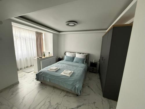 a bedroom with a bed and a large window at City Hall Deluxe Studio in Craiova