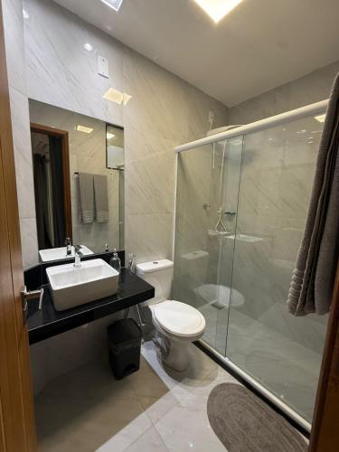 ein Badezimmer mit Toilette, Waschbecken und Dusche in der Unterkunft RM Hospedage Unidade Amapa 2 in Cabo Frio