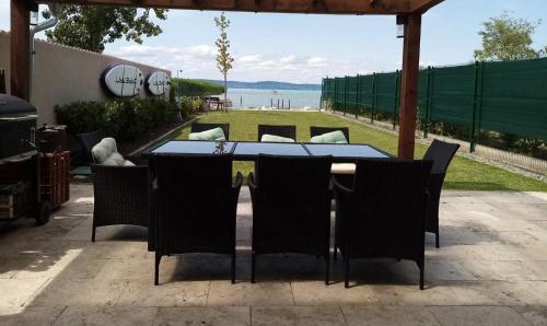 IHB-Inter House of Balaton في زاماردي: طاولة وكراسي في فناء مطل على المحيط