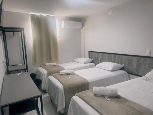 ein Krankenzimmer mit drei Betten und einem Fenster in der Unterkunft FLATS CAMPINA GRANDE - BSH FLATS - Melhor custo benefício in Campina Grande