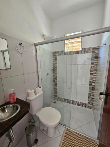 a bathroom with a toilet and a shower and a sink at Ap Aconchego Carapitangui in Barra Grande