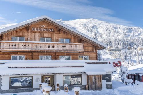 a log cabin in the snow with a sign on it at Bergnest die Frühstückspension in Katschberghöhe