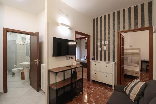een woonkamer met een bank en een televisie bij Charming 2 Suite Apt - 20 min Colosseo & Metro 5 min in Rome