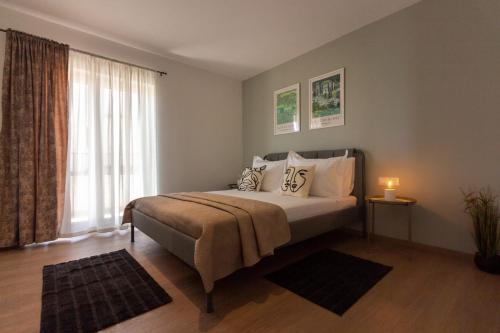 a bedroom with a bed and a large window at Apartmani Ljubica in Duće
