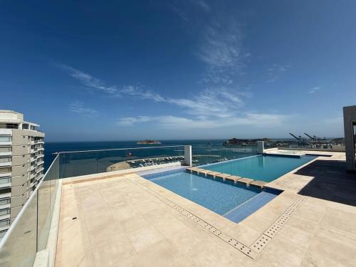 Corredor Suite - Eira Building - Santa Marta في سانتا مارتا: مسبح فوق مبنى مطل على المحيط