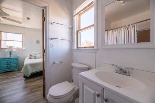 Un baño blanco con inodoro y lavabo. en D0311 The Sailfish. Private Pool, Hot Tub, Sound Views, Pool Table, Pets OK!, en North Point