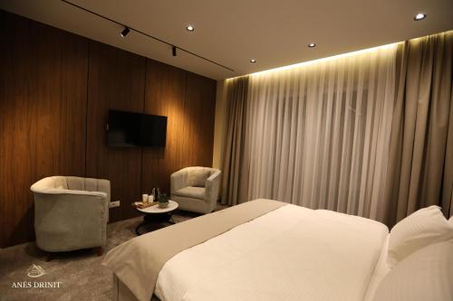 a hotel room with a bed and a table and chairs at Resort Anes Drinit in Peje