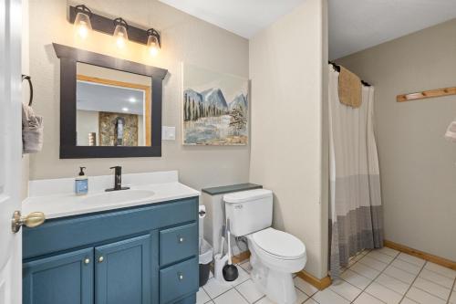 Deadwood Pines Hideaway في ستورجيس: حمام مع حوض أزرق ومرحاض