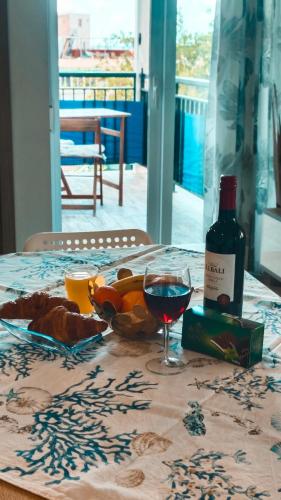 a table with a bottle of wine and a bowl of fruit at Apartamento Rosamar, sea view in Los Cristianos