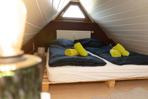 a bed with two yellow pillows on top of it at Bremen-Weyhe - peaceful - kitchen - wifi in Weyhe