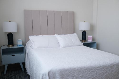 a bedroom with a white bed with two lamps at Providencia Amealco in Amealco