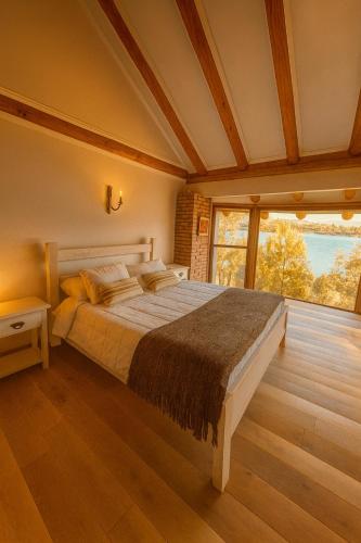 a bedroom with a bed and a large window at Beachfront house for 20 people in Vichuquén Lake