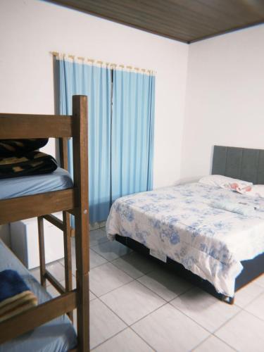 una camera da letto con un letto, una sedia e una finestra di Hotel e Churrascaria Major a Major