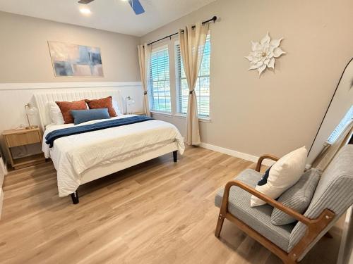 Modern and Cozy 3BR Retreat Perfect for Families or Big Group في سيدار بارك: غرفة نوم بها سرير وكرسي