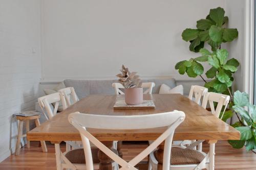 Un comedor con mesa y sillas de madera. en Peter Cottage - CBD Location Bright & Homely, en Wagga Wagga