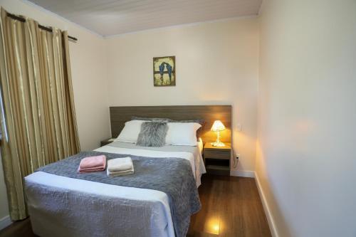 Ένα ή περισσότερα κρεβάτια σε δωμάτιο στο Aconchego de 2 dorm - 5 km Centro Gramado