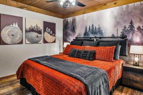 a bedroom with a large bed with an orange blanket at Hey Diddle Diddle cabin in Pigeon Forge