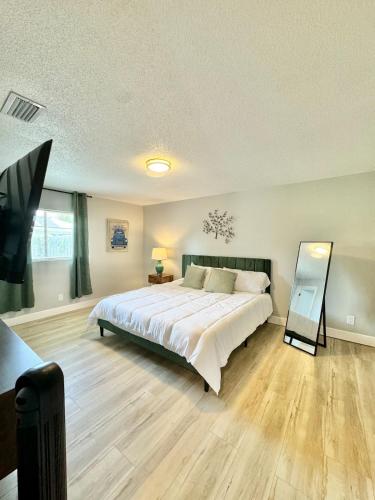 a bedroom with a large bed and a mirror at Modern cozy Home Palm Coast in Palm Coast