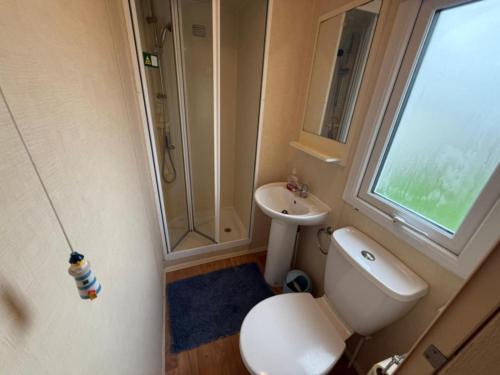 Un baño pequeño con inodoro y lavabo. en JTD golden gate caravan park towyn hire, en Kinmel Bay